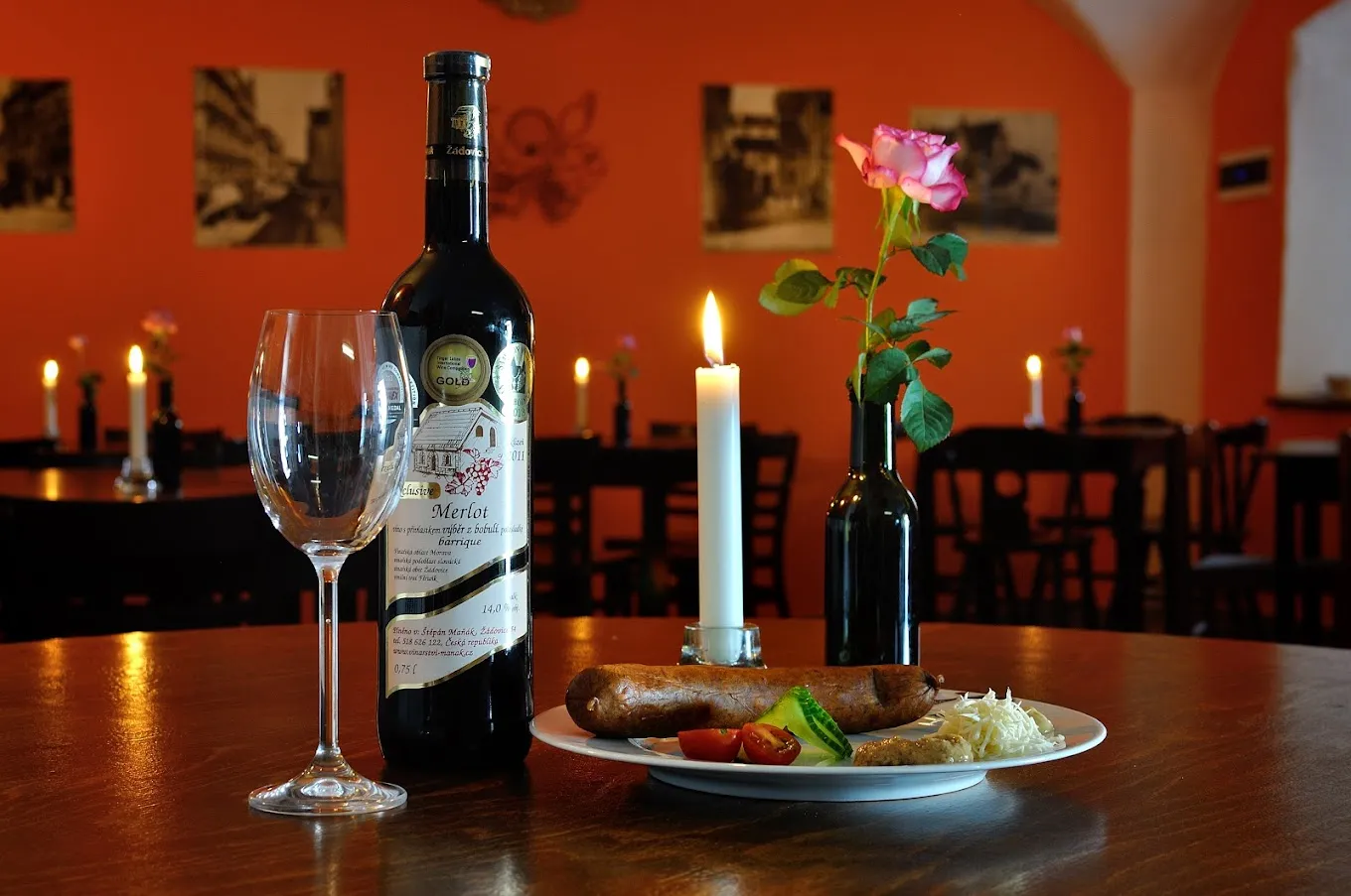 Wein, eine Kerze und eine Rose auf einem Tisch in der Vinotéka u Lípy